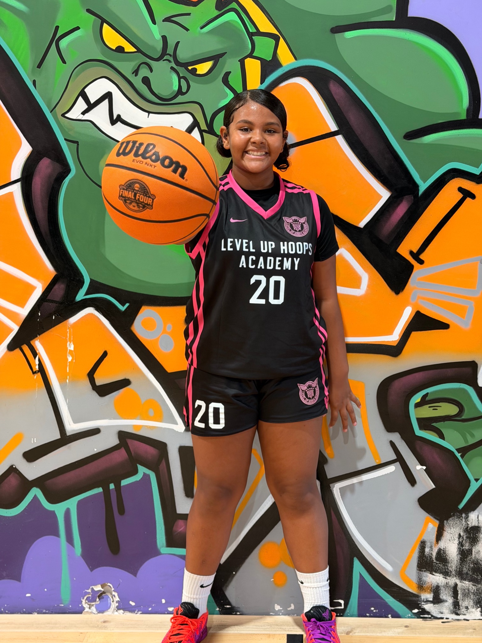 A Level Up athlete holding a basketball at the academy