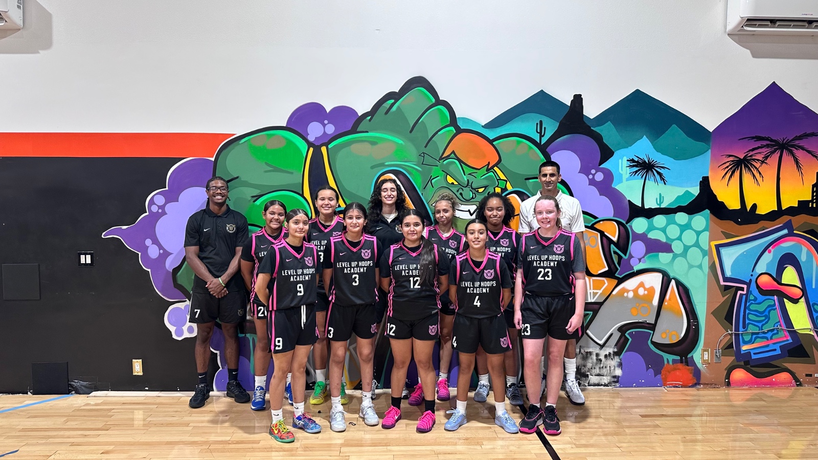 Level Up girls basketball team with their coaches